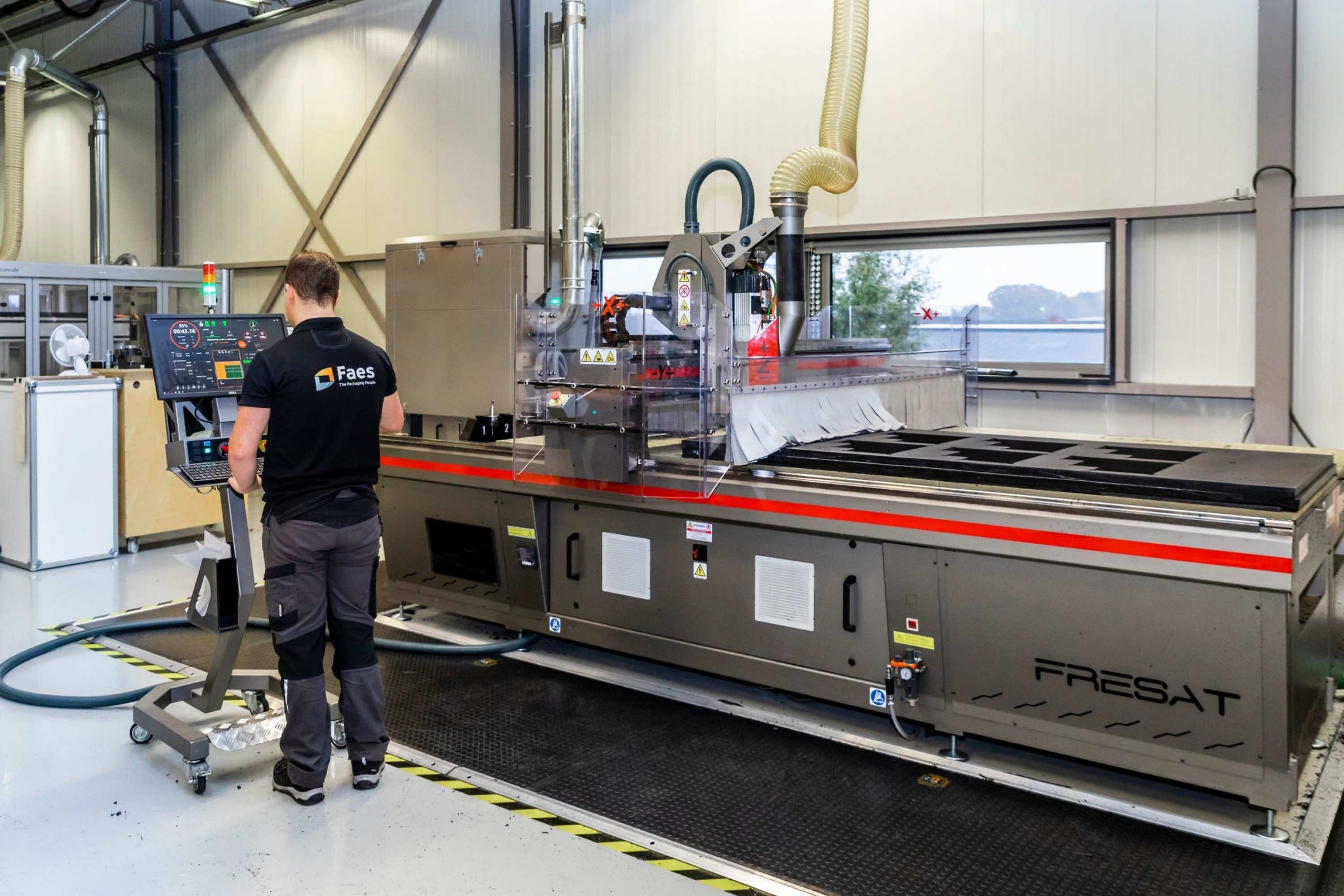 Medewerker van Faes bedient een CNC-machine voor het nauwkeurig bewerken van verpakkingsonderdelen, passend bij beschermende maatwerkverpakkingen die producten helpen beschermen tegen omgevingsinvloeden en transportschade.