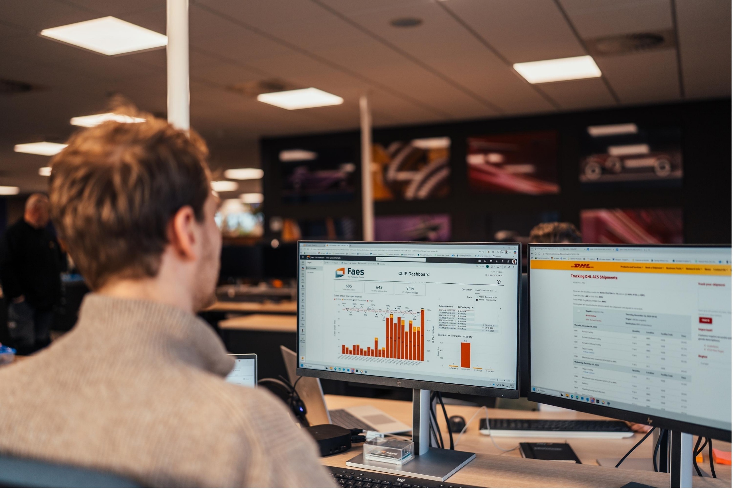 Medewerker van Faes bekijkt op kantoor dashboards en verzendinformatie op meerdere schermen, passend bij het gebruik van data om total cost of ownership en strategische inkoop beter te onderbouwen.