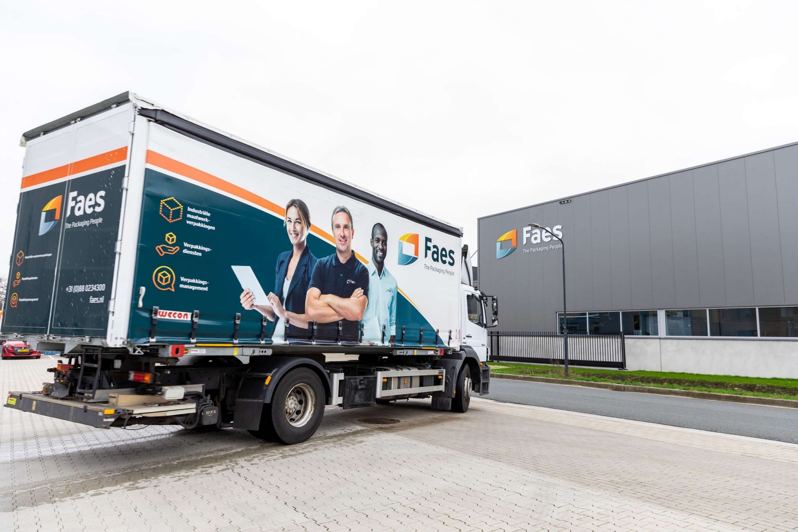 Faes vrachtwagen staat naast het bedrijfspand van Faes, passend bij het thema total cost of ownership in industriële logistiek.