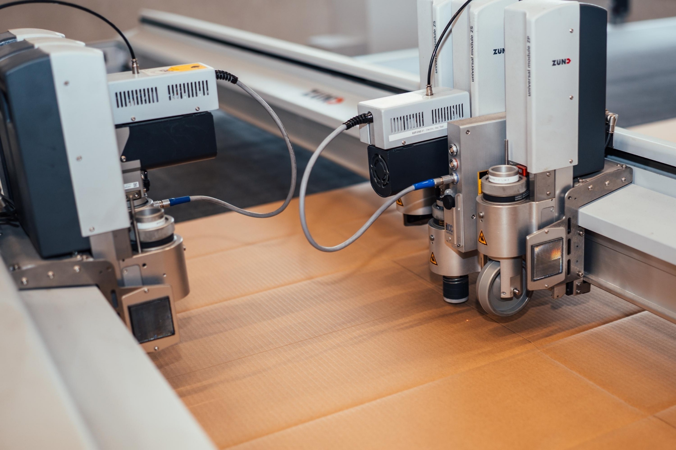 Digitale snijmachines bij Faes verwerken verpakkingsonderdelen op een vlakke snijtafel, als onderdeel van een doordacht verpakkingsproces gericht op schadebeperking en het voorkomen van DOA-kosten.