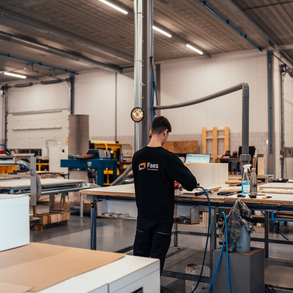 Medewerker van Faes werkt in de productiehal aan industriële verpakkingsonderdelen, passend bij circulaire verpakkingsoplossingen met een langere gebruiksduur.
