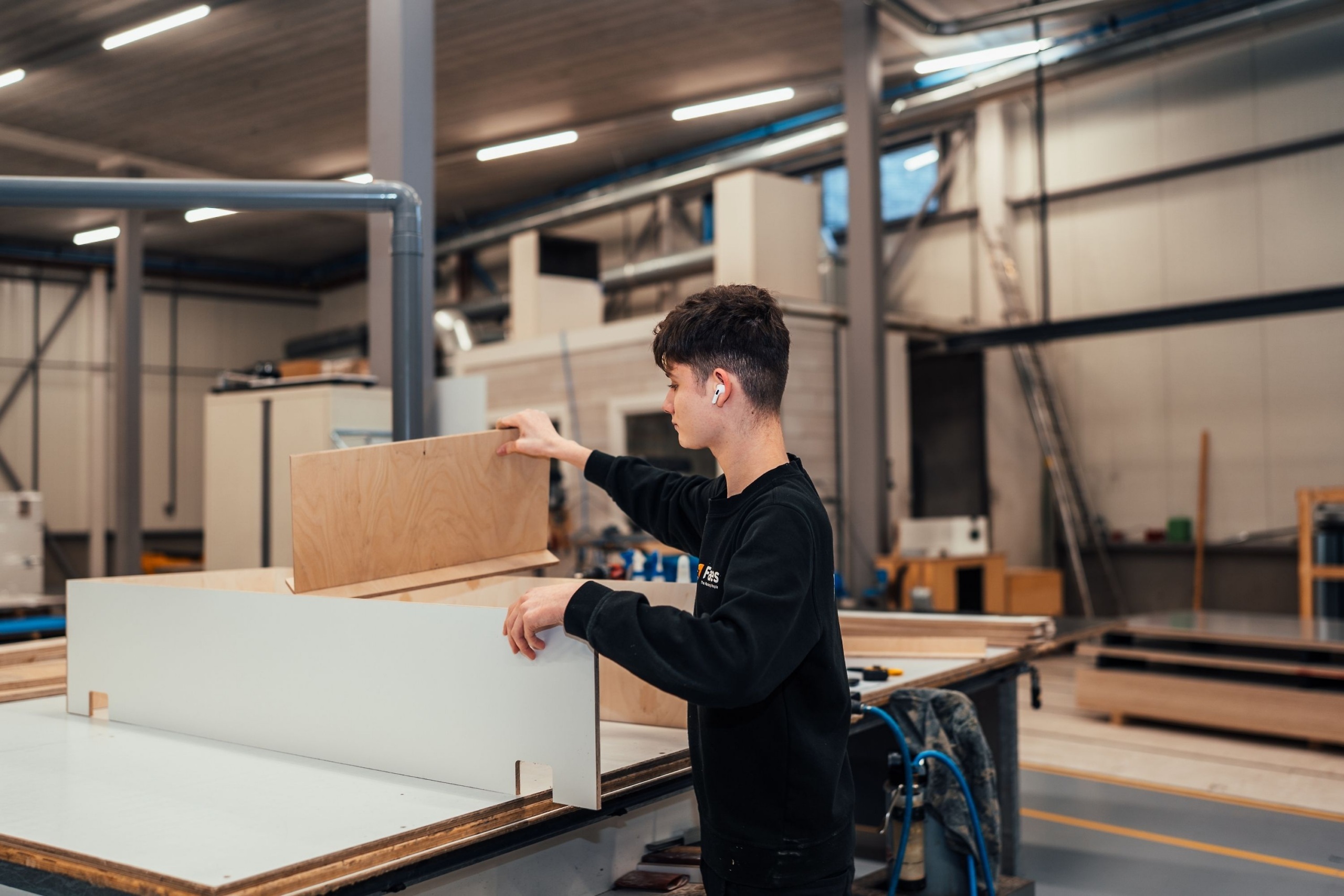 Medewerker van Faes assembleert in de productiehal een houten legerkist, passend bij maatwerk transportverpakkingen voor stevige en efficiënte bescherming.