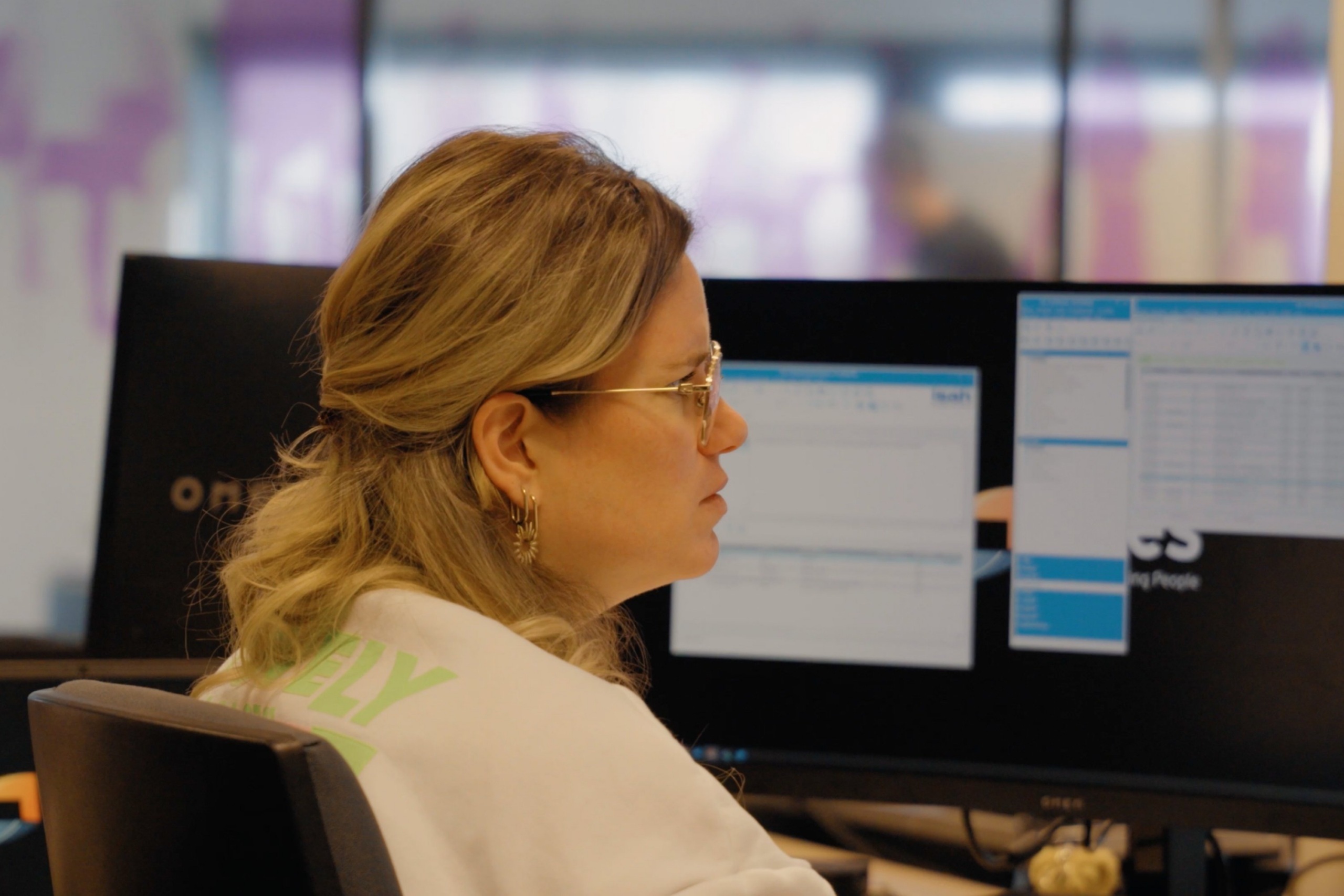 Medewerker van Faes bekijkt gegevens op meerdere schermen, passend bij het analyseren van TCO en het afwegen van herbruikbare versus eenmalige verpakkingen.