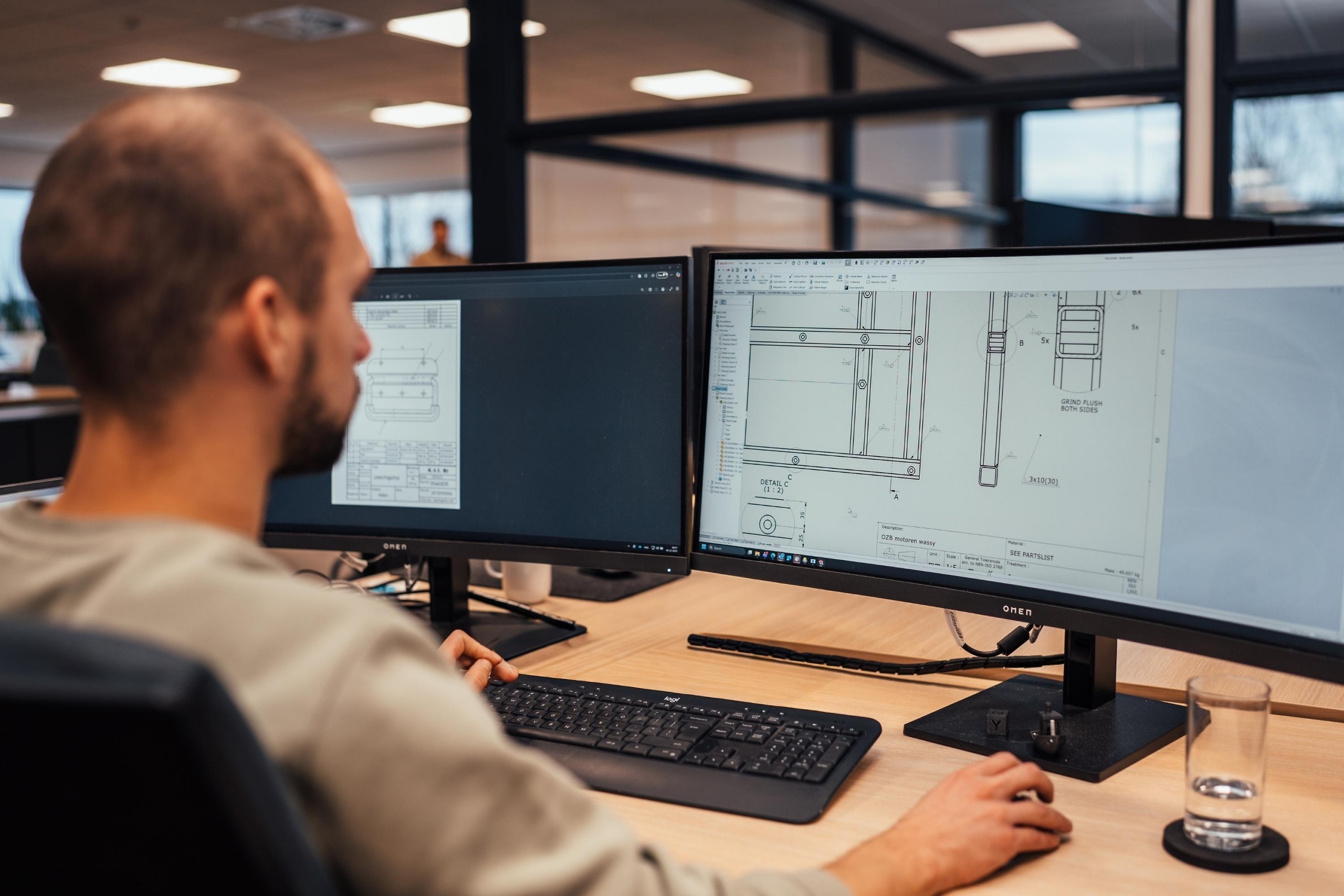 Engineer van Faes beoordeelt technische tekeningen van een verpakkingsconstructie, passend bij het ontwerpen en voorbereiden van IP-tests voor stof- en waterdichtheid.