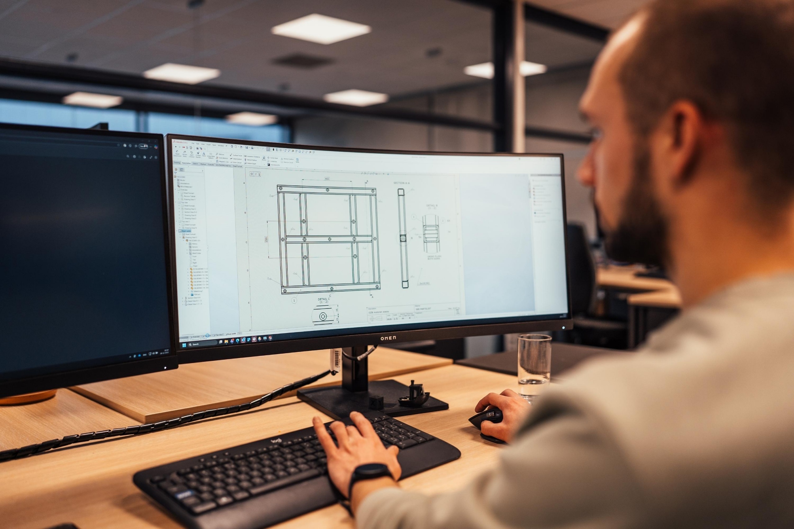 Medewerker van Faes bekijkt op kantoor een technische tekening op een computerscherm, passend bij verpakking als engineeringvraagstuk.