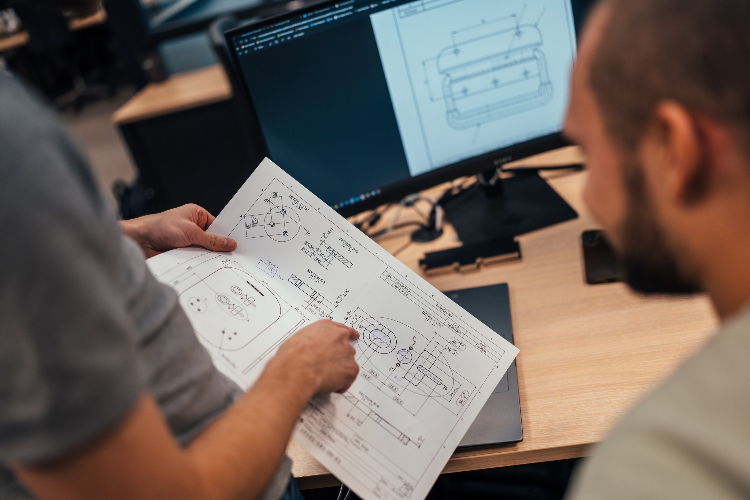 Engineers beoordelen een technische tekening voor maatwerk industriële verpakking die transportschade helpt verminderen en dead-on-arrival zendingen voorkomt.
