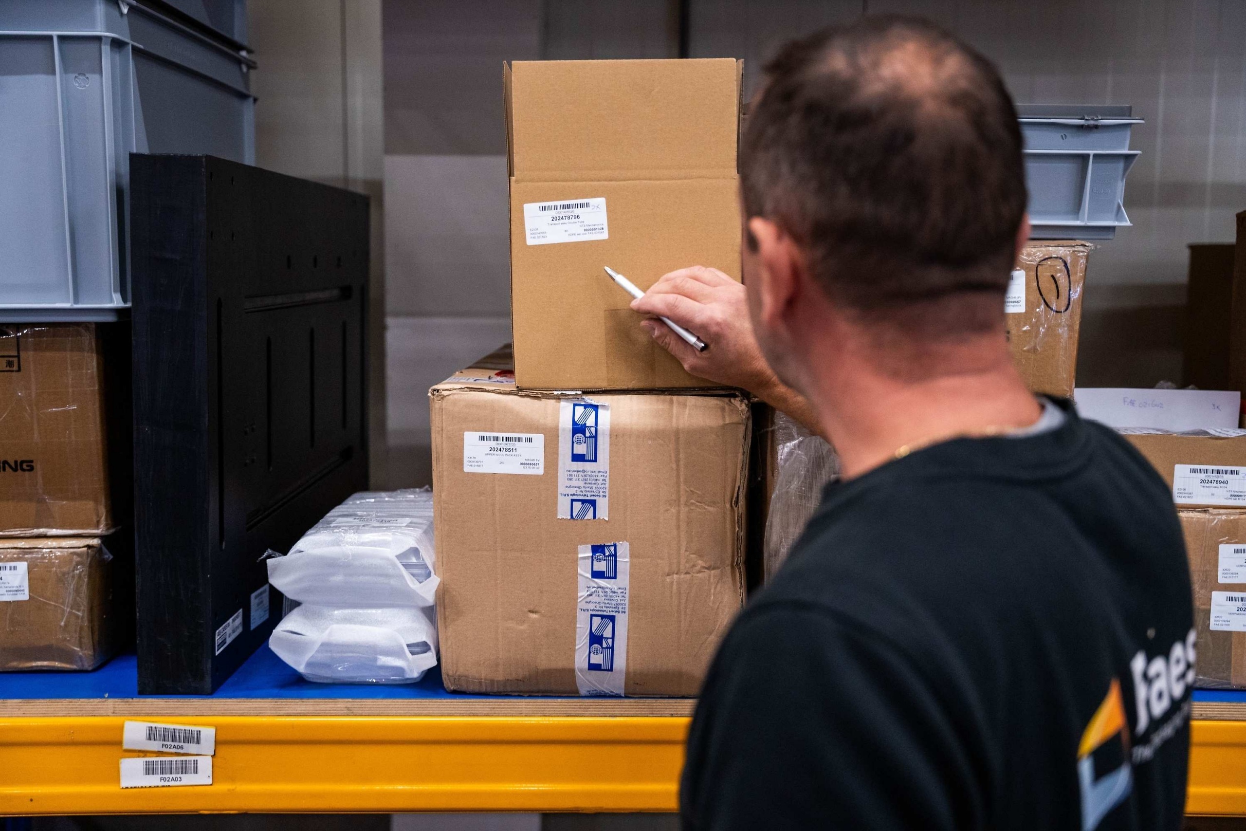 Medewerker van Faes controleert en registreert gelabelde testverpakkingen, passend bij het zorgvuldig documenteren van testresultaten voor de certificering van transportkoffers.